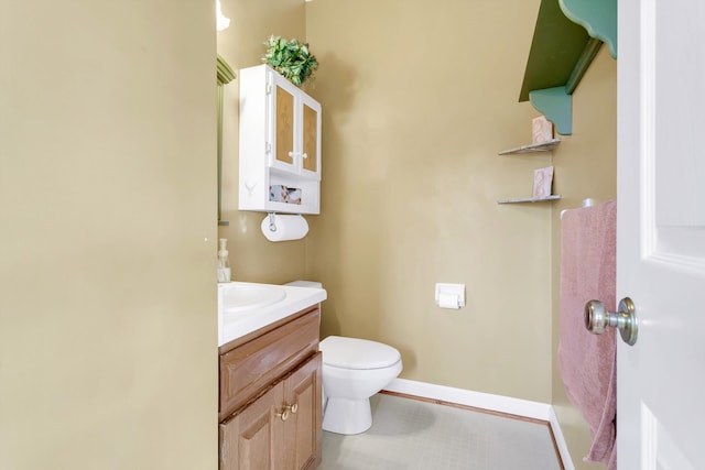 bathroom with toilet, vanity, and tile patterned floors