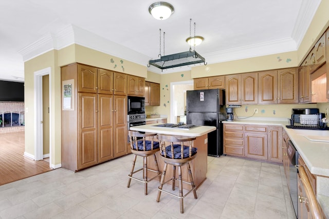 kitchen with light hardwood / wood-style flooring, a kitchen bar, crown molding, black appliances, and a kitchen island