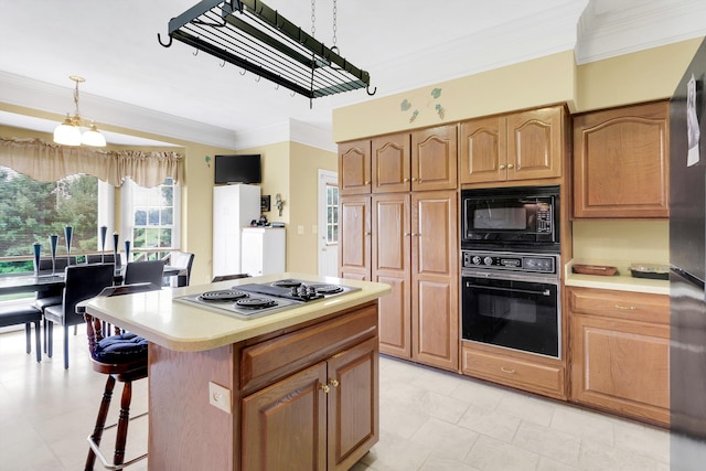 kitchen featuring ornamental molding, decorative light fixtures, a kitchen island, light tile patterned floors, and black appliances