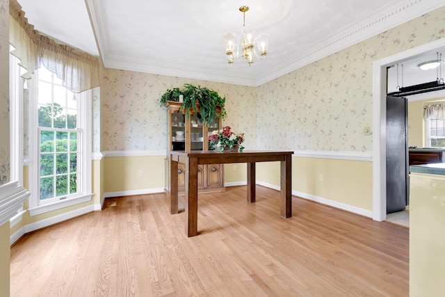 office space featuring light wood-type flooring, a notable chandelier, and ornamental molding