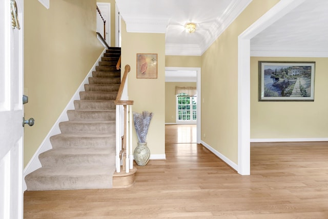 entryway featuring light wood-type flooring and crown molding