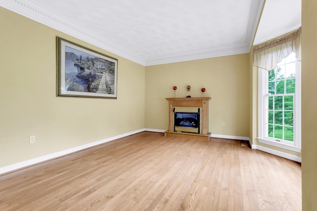 unfurnished living room with light hardwood / wood-style flooring, crown molding, and plenty of natural light