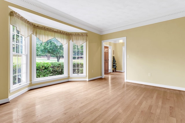 empty room featuring ornamental molding and light wood-type flooring