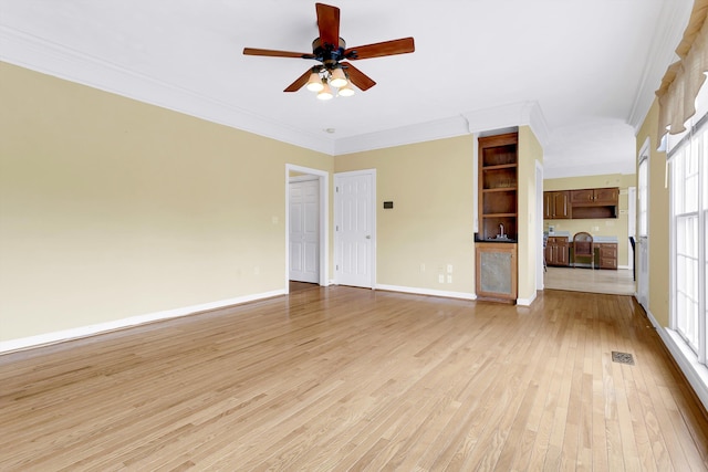 unfurnished living room featuring ceiling fan, light wood-type flooring, and crown molding