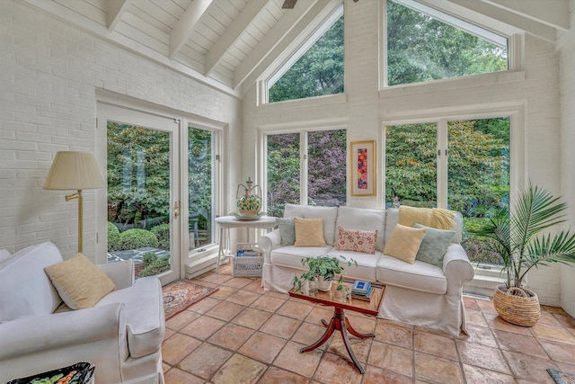 sunroom / solarium featuring vaulted ceiling with beams