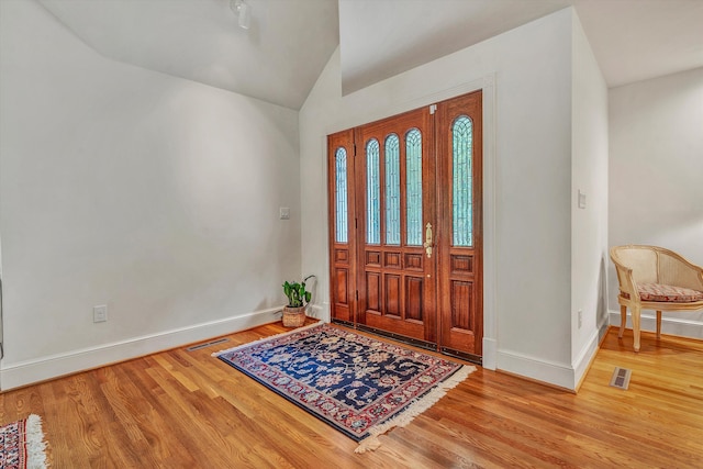 entrance foyer featuring hardwood / wood-style flooring and vaulted ceiling