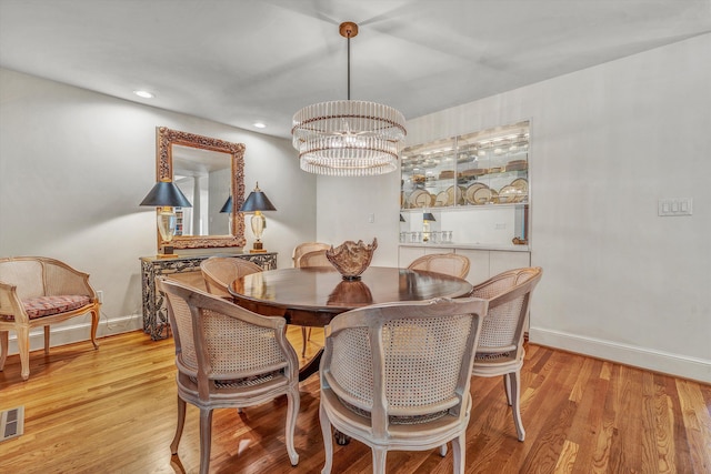 dining room featuring light hardwood / wood-style flooring and an inviting chandelier