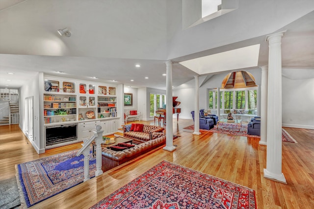 living room featuring light hardwood / wood-style floors and ornate columns