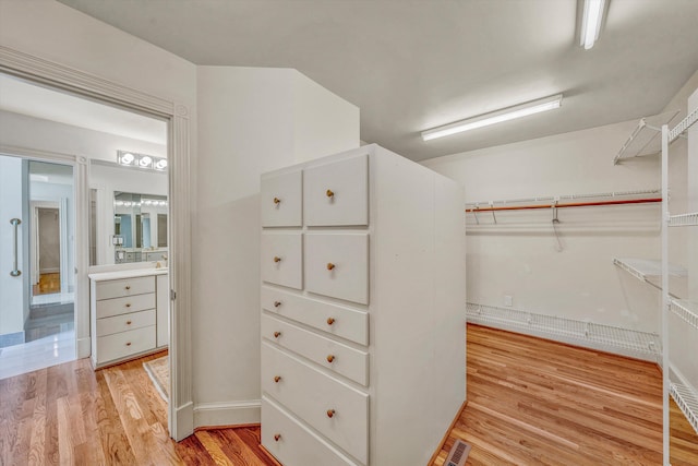 walk in closet with light wood-type flooring