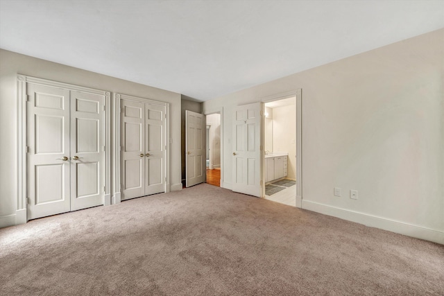 unfurnished bedroom featuring carpet flooring and ensuite bathroom