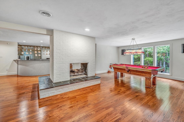 rec room featuring hardwood / wood-style floors, a fireplace, and pool table