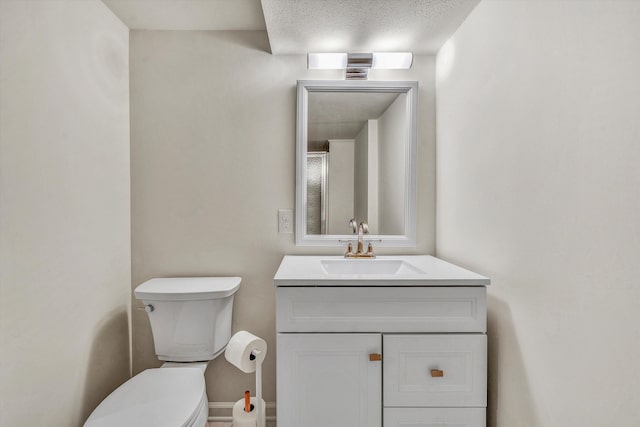 bathroom featuring vanity, a textured ceiling, and toilet