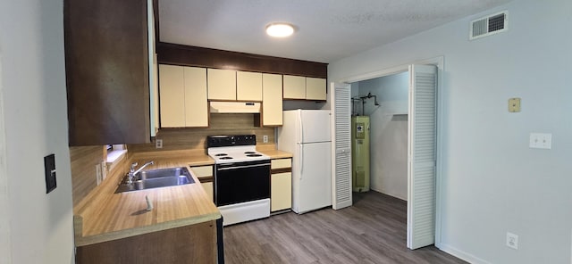 kitchen featuring sink, a textured ceiling, white appliances, light hardwood / wood-style floors, and backsplash