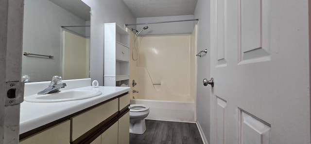 full bathroom with washtub / shower combination, toilet, a textured ceiling, vanity, and hardwood / wood-style flooring