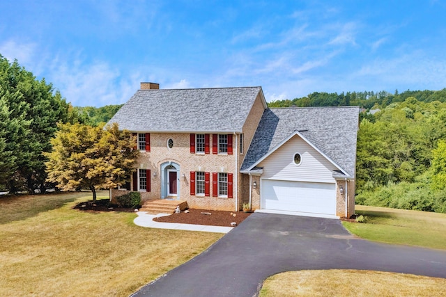 colonial home featuring a garage and a front yard