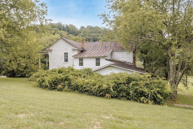 back of property with a balcony, covered porch, and a yard