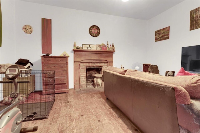 living room featuring a brick fireplace and light wood-type flooring