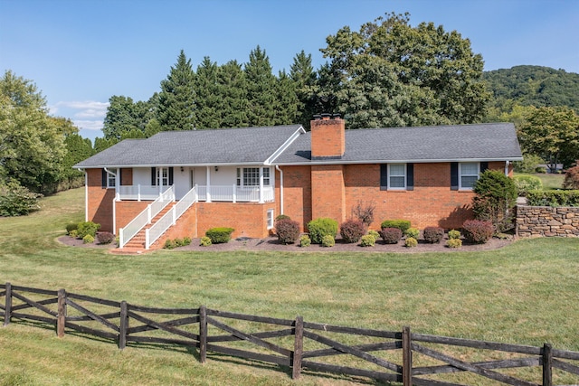 single story home featuring brick siding, a chimney, and a front lawn