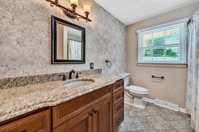 full bathroom featuring toilet, vanity, visible vents, and baseboards