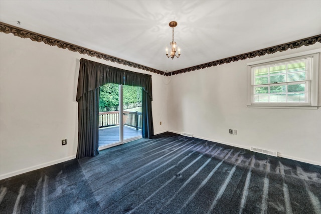 empty room with dark colored carpet, plenty of natural light, visible vents, and baseboards