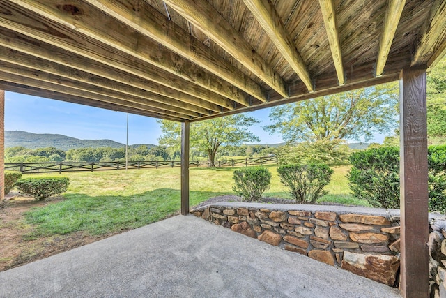 view of patio with fence and a mountain view