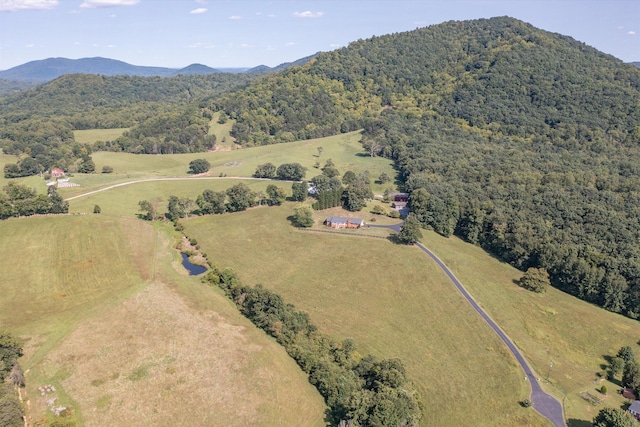 birds eye view of property featuring a mountain view and a wooded view