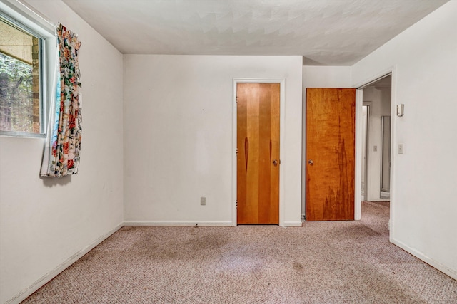 unfurnished bedroom featuring light carpet