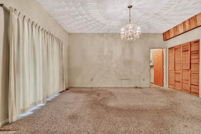 carpeted empty room with a chandelier