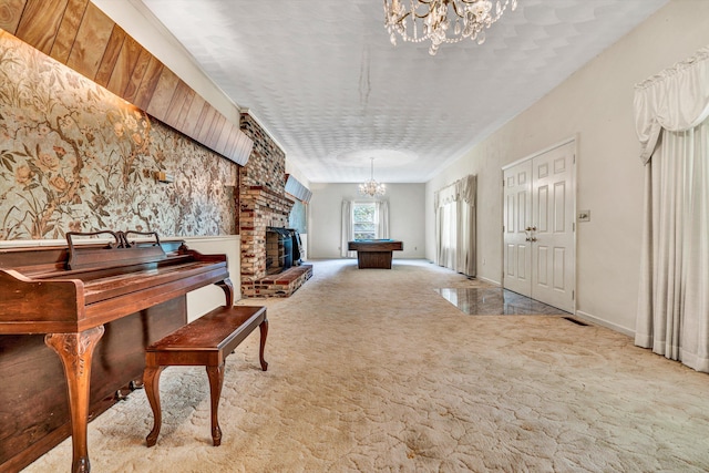 misc room featuring a notable chandelier, a fireplace, and light colored carpet