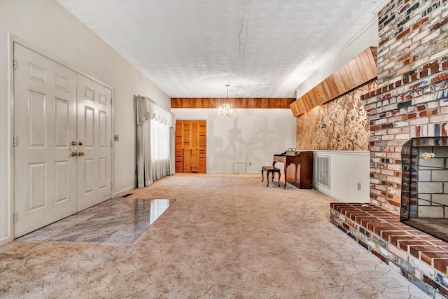 foyer entrance featuring a textured ceiling, a chandelier, and wood walls