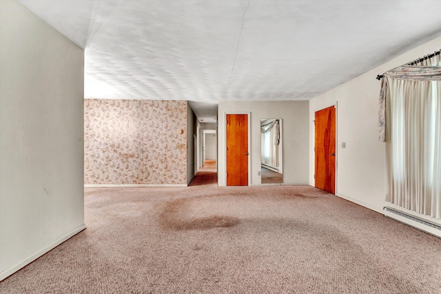 carpeted spare room featuring a baseboard radiator