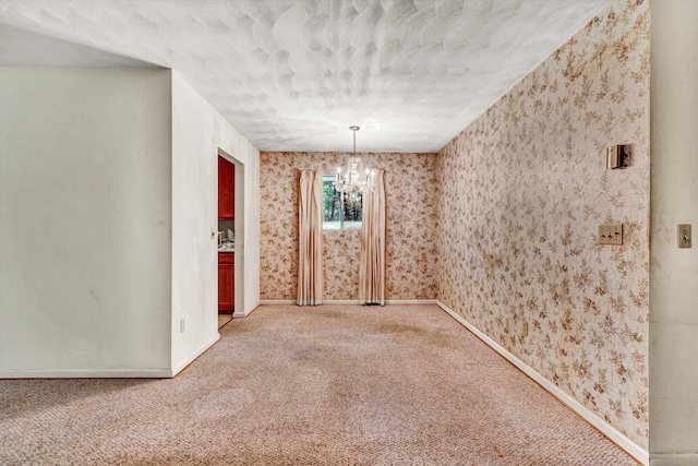 unfurnished room featuring carpet flooring and a notable chandelier