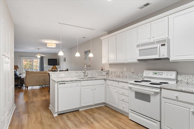 kitchen with white appliances, sink, decorative light fixtures, light hardwood / wood-style floors, and white cabinetry