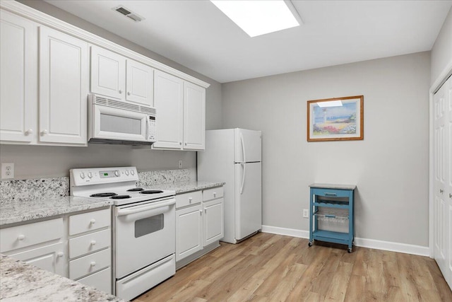 kitchen with white cabinetry, light hardwood / wood-style flooring, light stone counters, and white appliances