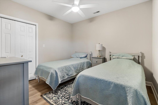 bedroom featuring ceiling fan, a closet, and light wood-type flooring