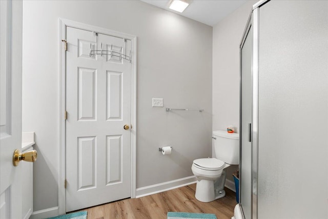 bathroom featuring wood-type flooring, vanity, toilet, and walk in shower