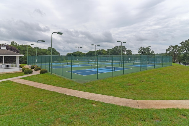 view of tennis court featuring a lawn