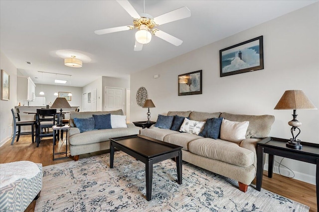 living room with ceiling fan and wood-type flooring