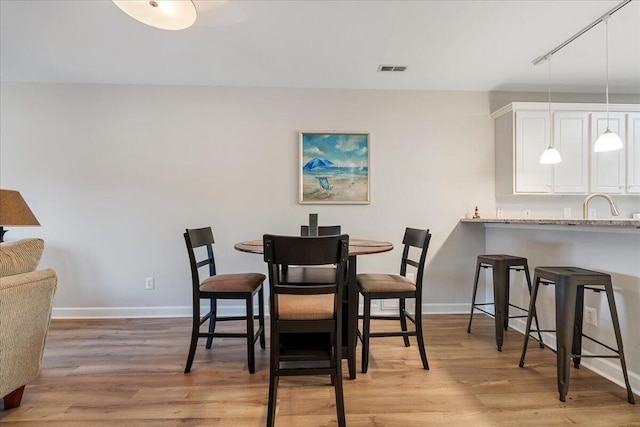 dining space featuring light hardwood / wood-style flooring and sink