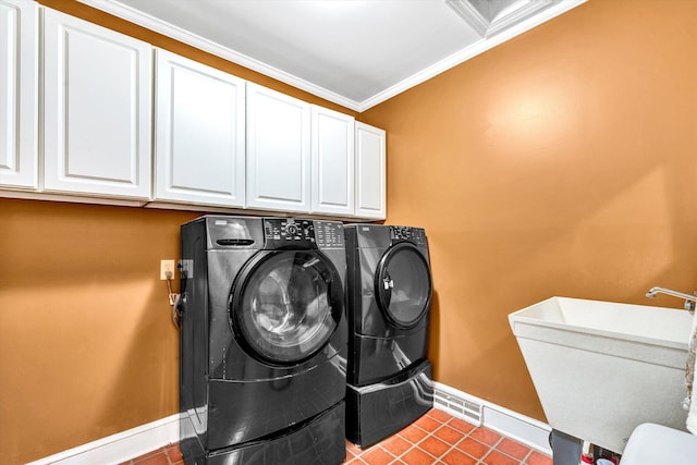 washroom with cabinets, crown molding, light tile patterned flooring, washer and dryer, and sink