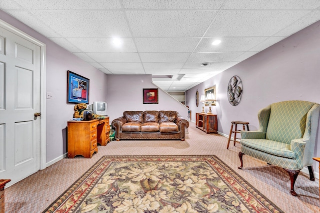 carpeted living room with a paneled ceiling