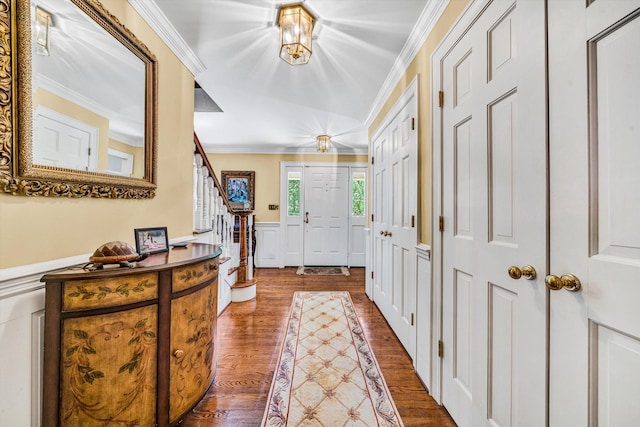 foyer entrance with dark wood-type flooring and crown molding