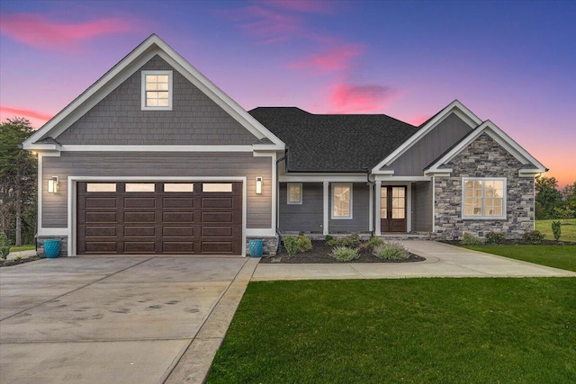 craftsman-style house with a yard, concrete driveway, and an attached garage