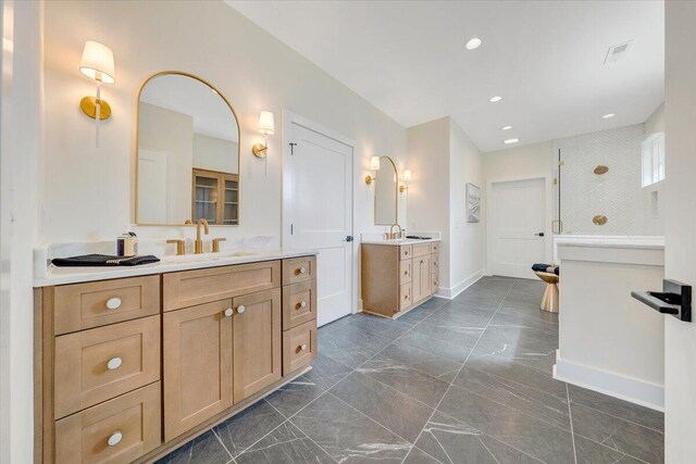 bathroom featuring baseboards, two vanities, a sink, a walk in shower, and marble finish floor