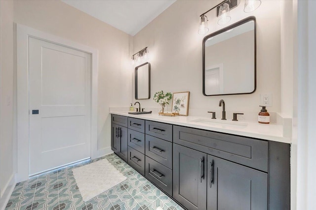 full bathroom featuring double vanity, baseboards, and a sink