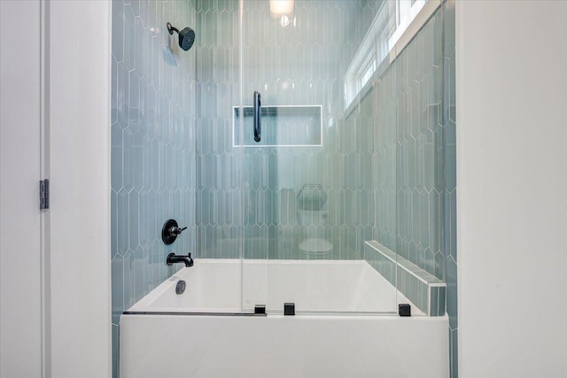 bathroom with shower / bath combination with glass door