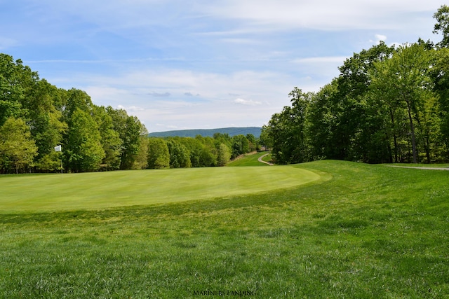 view of property's community with a yard and view of golf course