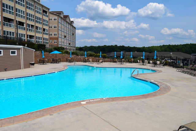 community pool with a patio and fence