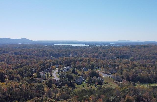 drone / aerial view featuring a water and mountain view and a wooded view