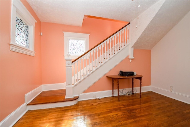 stairs featuring hardwood / wood-style flooring and a textured ceiling